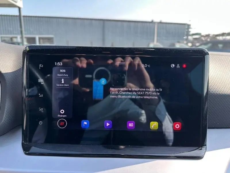 Écran tactile central du tableau de bord du SEAT Arona 2025 affichant le menu Bluetooth, avec reflet de la cabine.