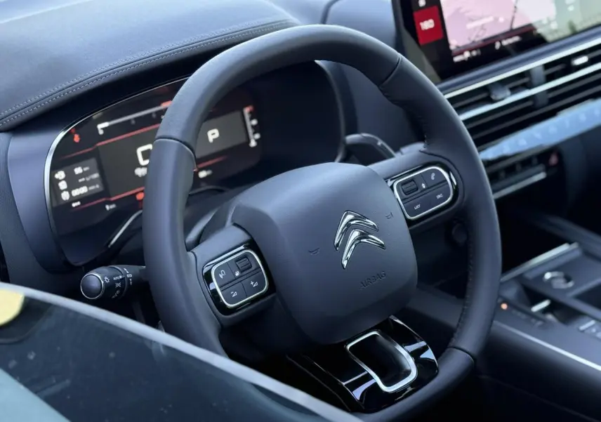 Volant en cuir noir avec commandes intégrées et tableau de bord numérique du Citroën C5 Aircross 2025, ambiance intérieure moderne.
