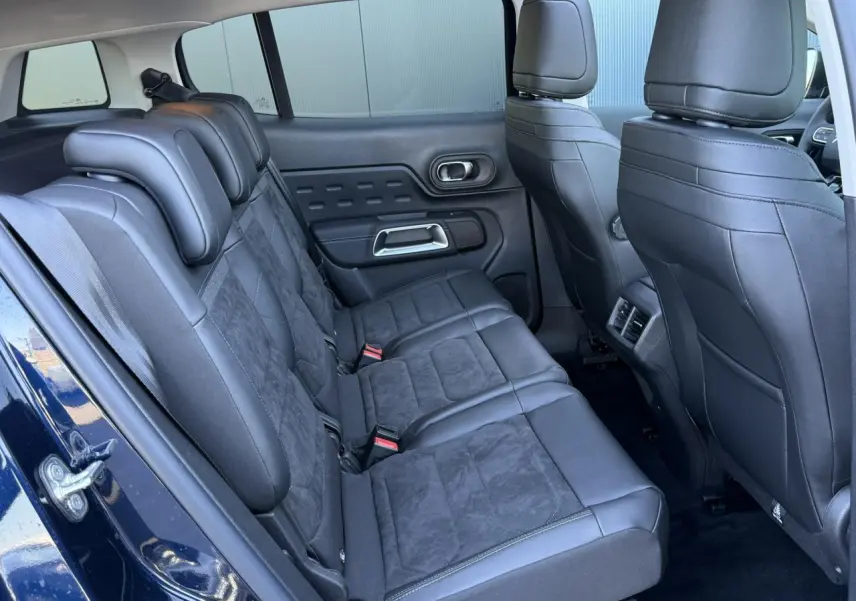 Vue intérieure arrière gauche des sièges en alcantara noir du Citroën C5 Aircross Bleu Eclipse avec portes ouvertes.