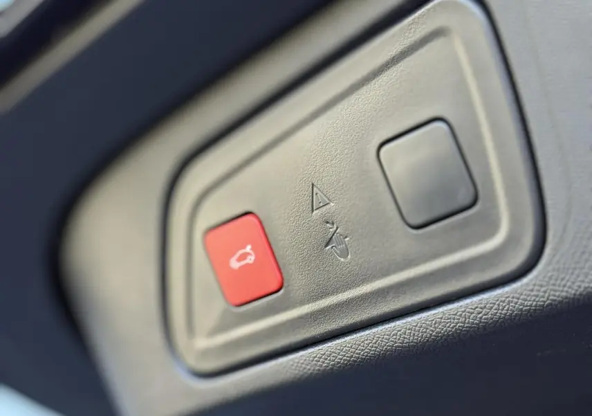Gros plan sur le bouton rouge d'ouverture du hayon électrique dans l'habitacle du Citroën C5 Aircross Bleu Eclipse.