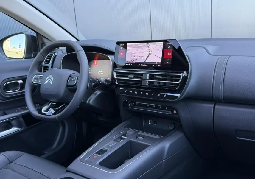 Vue intérieure côté conducteur du tableau de bord noir avec écran tactile et volant Citroën du C5 Aircross 2025.