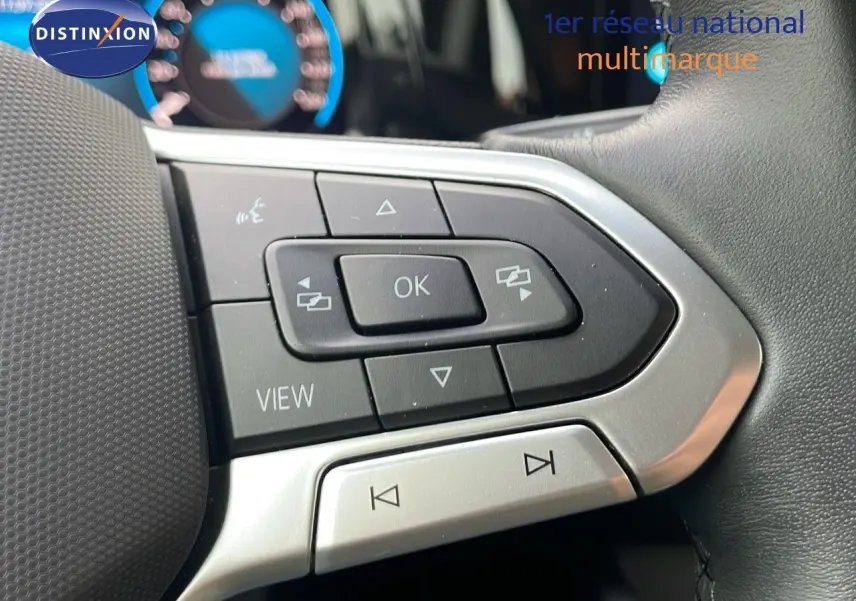 Gros plan sur les commandes gauche du volant d'une Volkswagen Golf VIII 2023, avec boutons noirs et contours argentés.