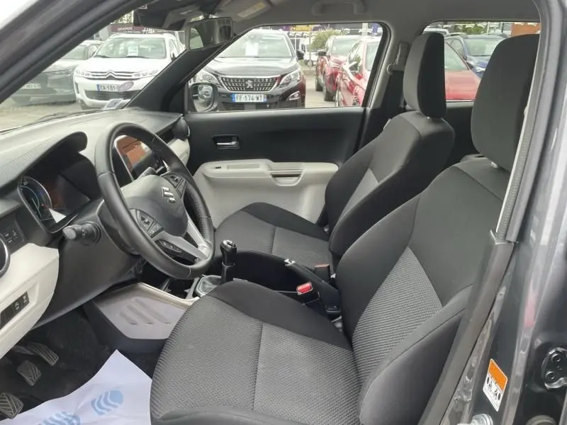 Intérieur de la Suzuki Ignis 1.2 Dualjet Hybrid 2020, vue côté conducteur, sièges noirs et tableau de bord clair.