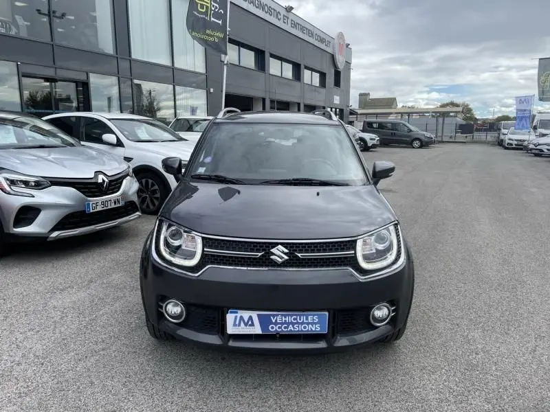 Vue frontale d'une Suzuki Ignis 1.2 Dualjet Hybrid SHVS Pack gris foncé métal, avec phares LED et plaque "Véhicules Occasions".