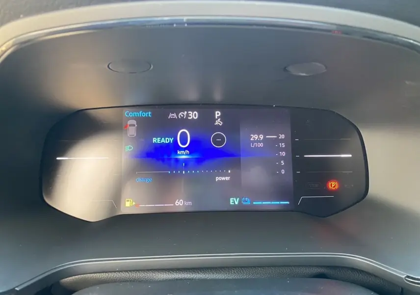 Tableau de bord numérique du Renault Captur 2025 en vue frontale, affichant la vitesse à 0 km/h et l'autonomie hybride.