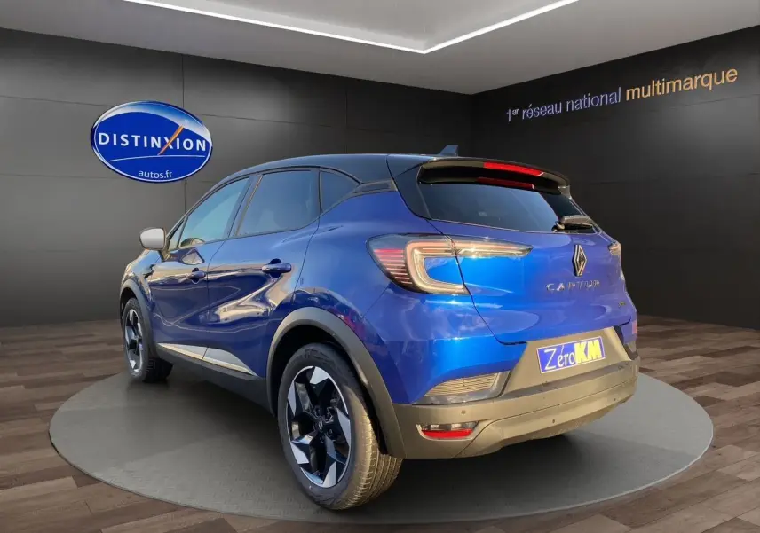 Vue 3/4 arrière droite du Renault Captur 2025 bleu Iron avec toit noir et jantes noires distinctives.