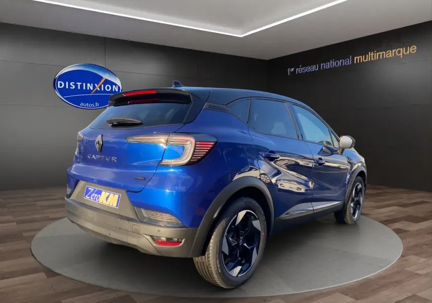 Renault Captur 2025 bleu Iron en 3/4 arrière droit avec toit noir et jantes alliage distinctives.