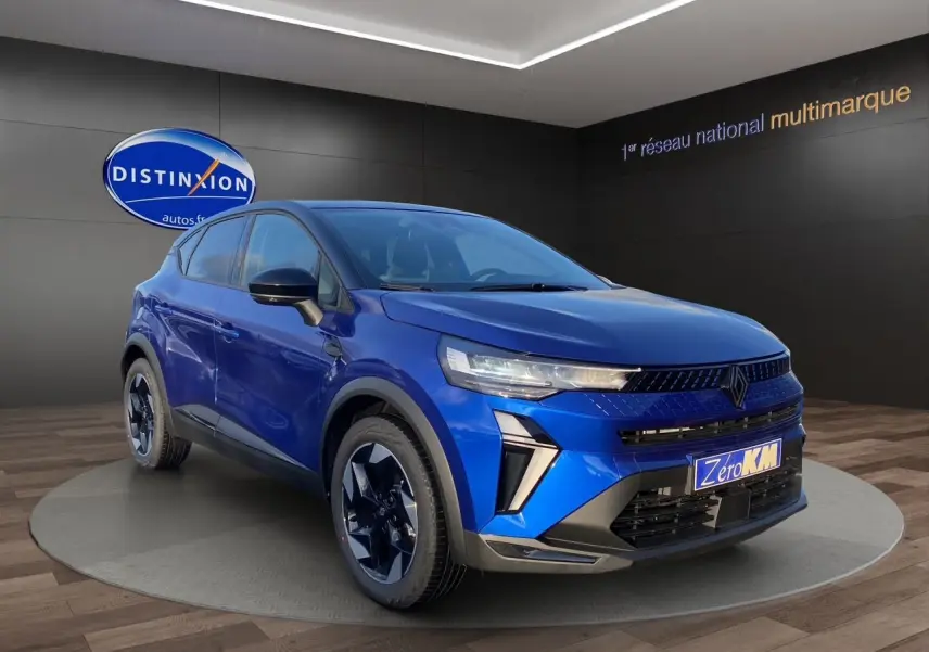 Renault Captur 2025 bleu Iron avec toit noir, vue 3/4 avant droit mettant en valeur ses optiques fines et jantes stylées.