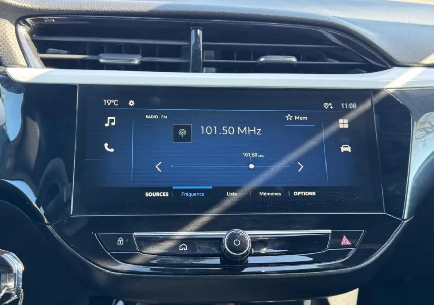 Écran tactile central de l’Opel Corsa rouge 2025 affichant la radio FM à 101,50 MHz avec commandes sous l’écran.