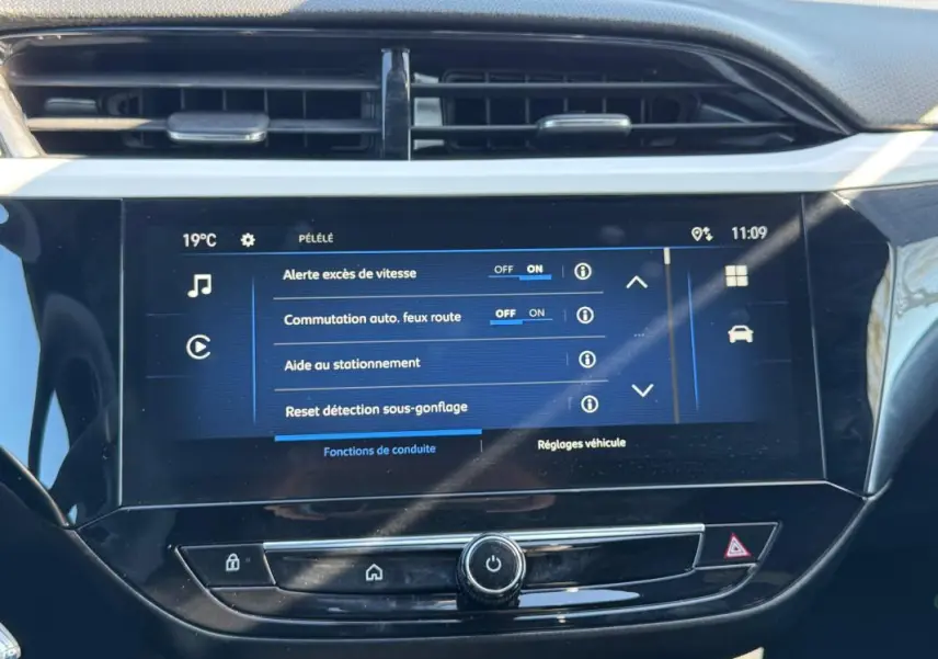 Écran tactile central de l’Opel Corsa rouge 2025 affichant les réglages d’aide à la conduite et d’éclairage.