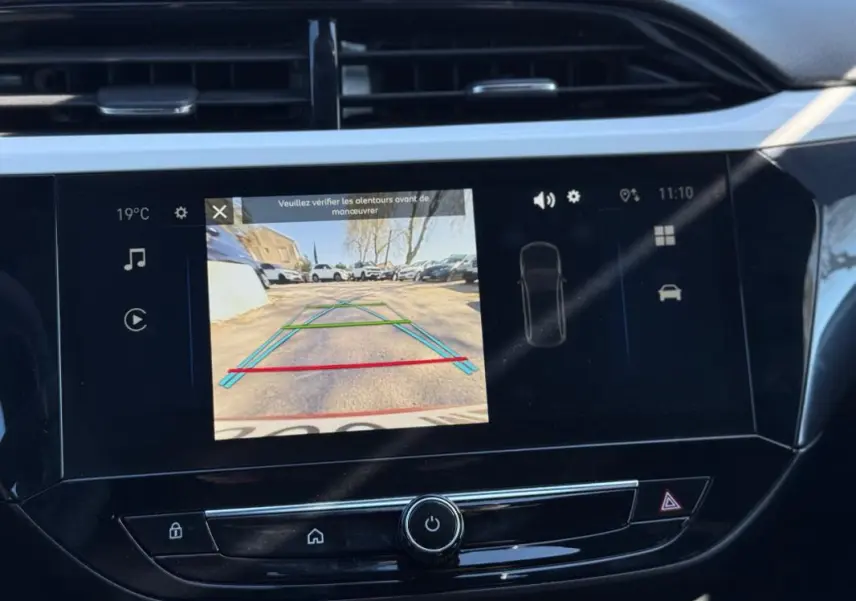 Écran central de l’Opel Corsa rouge 2025 montrant la caméra de recul avec les lignes de guidage colorées.