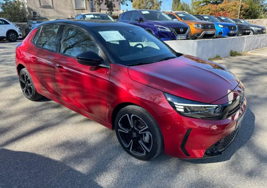 Opel Corsa rouge vue 3/4 avant droit, jantes alliage noires 17 pouces, calandre moderne et phares LED fins.