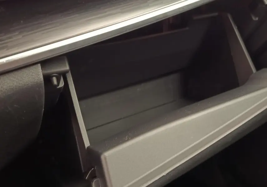 Gros plan sur la boîte à gants ouverte à l’intérieur du Nissan Qashqai noir, version Tekna 2023.