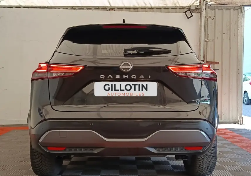 Vue arrière d’un Nissan Qashqai noir 2023 avec feux LED allumés et logo visible sur le hayon.