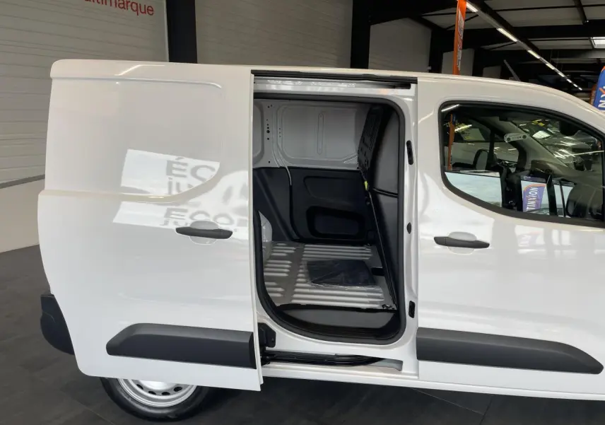 Vue latérale droite du Peugeot Partner blanc avec porte coulissante ouverte montrant l'espace de chargement vide.