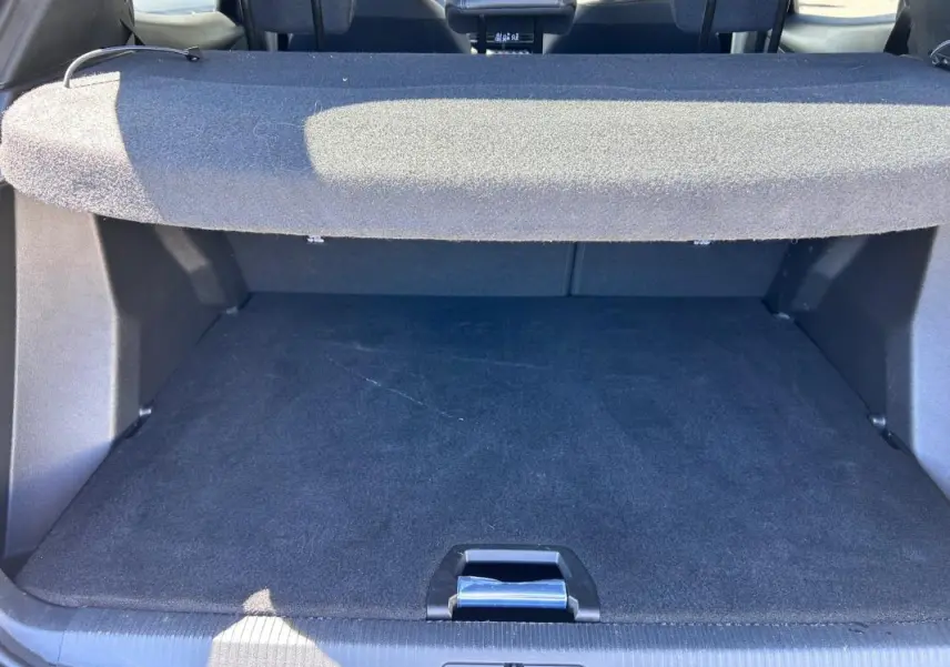Vue intérieure du coffre noir du Peugeot 2008 Hybrid 136 e-DCS6 Allure, avec cache-bagages déployé.
