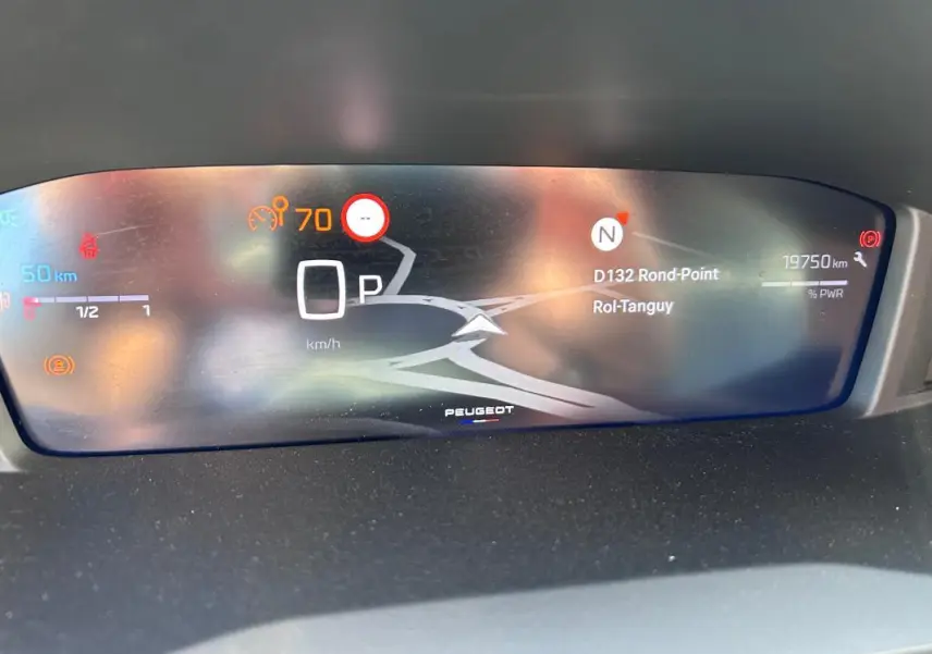 Affichage numérique du cockpit du Peugeot 2008 Hybrid 136, avec navigation et indicateurs de vitesse et distance.