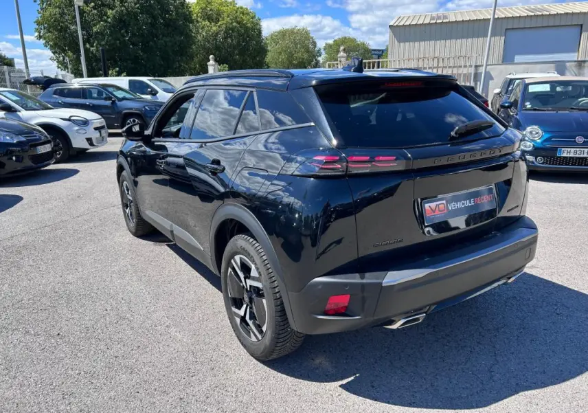 Peugeot 2008 Hybrid noir vue 3/4 arrière droit, avec barres de toit et jantes alliage 17 pouces visibles.