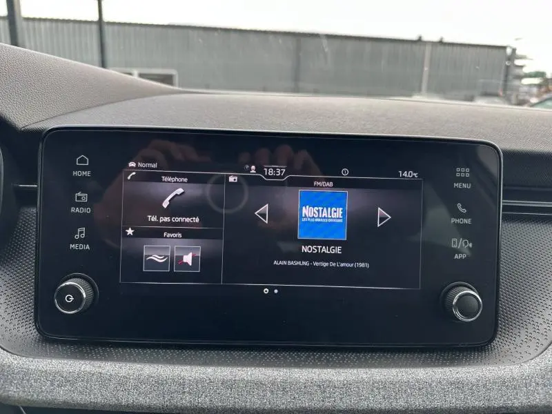Écran tactile central de la Skoda Scala blanc cristal 2025 affichant la radio numérique Nostalgie.
