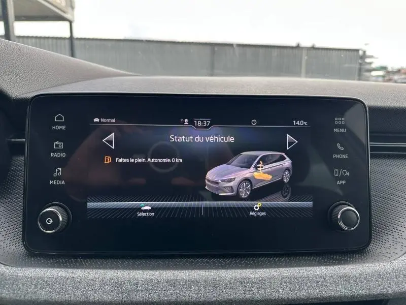 Écran tactile central affichant le statut du véhicule Skoda Scala blanc cristal en vue latérale droite.
