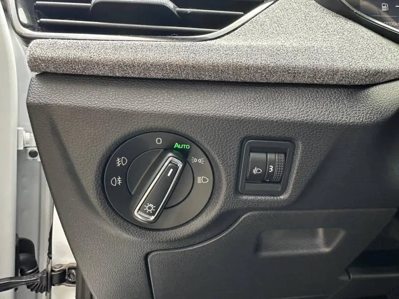 Détail du commutateur des feux avec réglage automatique sur Skoda Scala blanc cristal, intérieur côté conducteur.