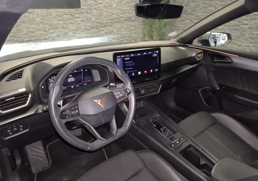 Intérieur avant droit de la CUPRA Leon Sportstourer gris, volant multifonction, écran tactile central et finitions Copper.