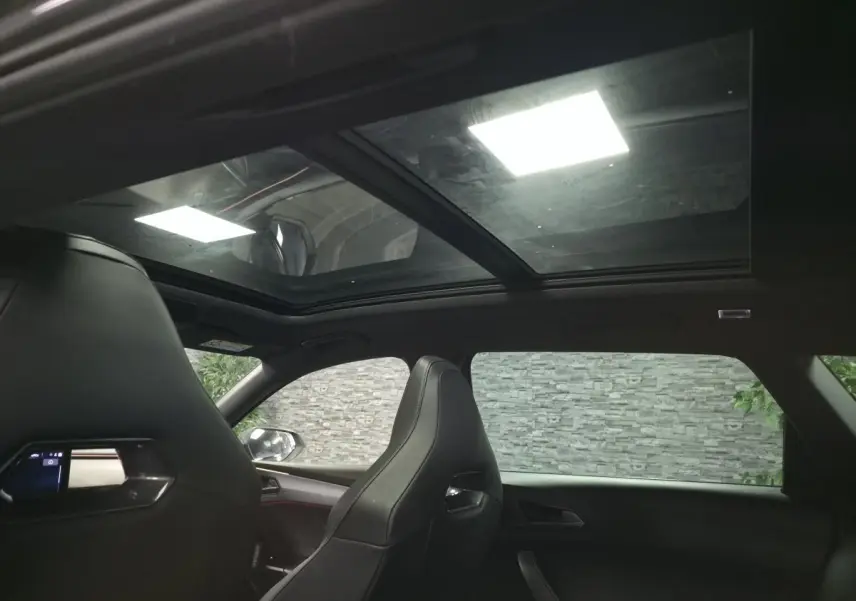 Vue intérieure du toit ouvrant panoramique et des sièges baquets noirs du Cupra Leon Sportstourer gris 2023.