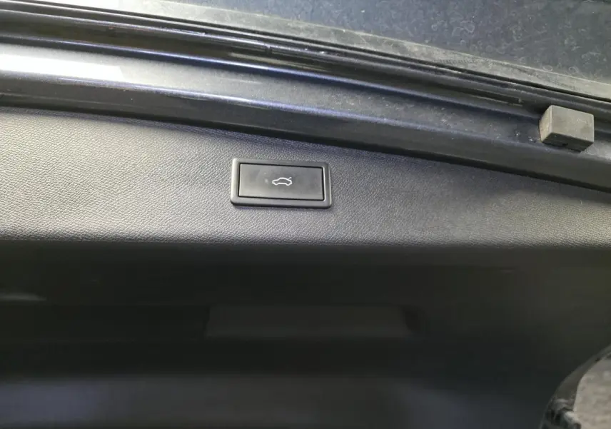 Bouton d'ouverture électrique du hayon sur la partie intérieure du coffre d'une CUPRA Leon Sportstourer gris.