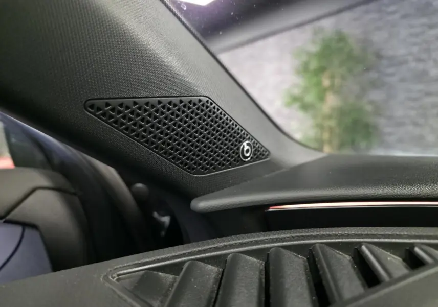 Gros plan sur l'enceinte Beats Audio intégrée au tableau de bord côté gauche d'un CUPRA Leon Sportstourer gris.