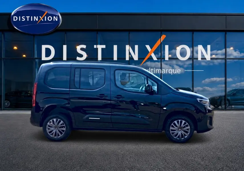 Profil côté gauche d'un Citroën Berlingo noir 2026 devant une vitrine avec logo Distinxion.