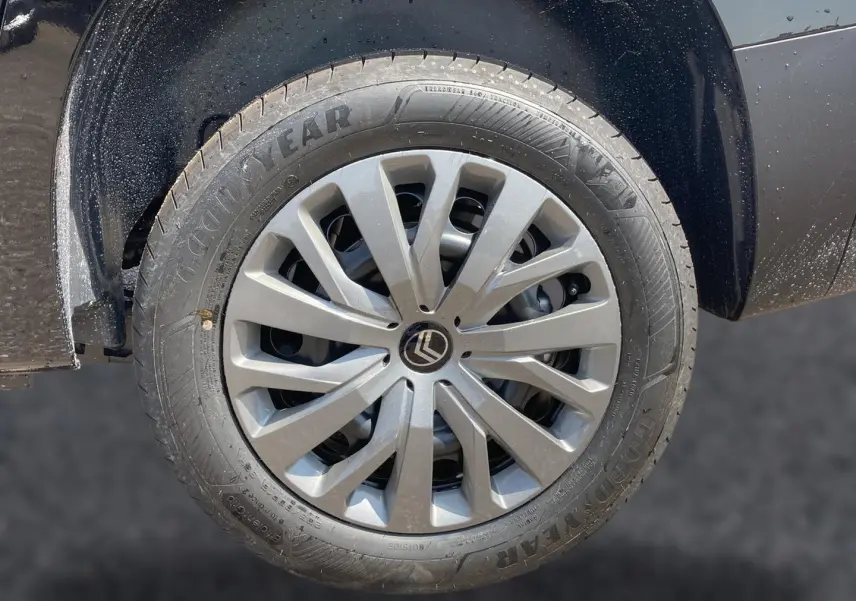 Gros plan sur la roue avant gauche noire d’un Citroën Berlingo 2026 avec jante alu et logo Citroën au centre.