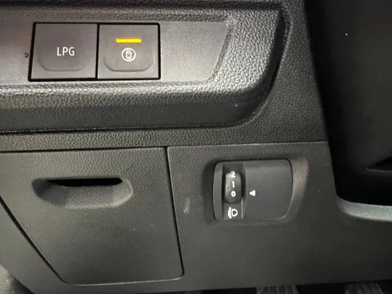Détail intérieur du tableau de bord du Dacia Jogger 2025, boutons de commande GPL et réglage des phares visibles.