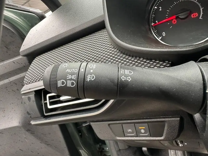 Gros plan sur la commande des feux et clignotants du Dacia Jogger 2025, intérieur avec détails du tableau de bord kaki lichen.