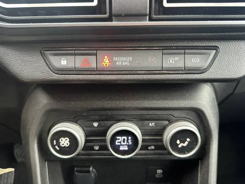 Vue rapprochée du tableau de bord central du Dacia Jogger 2025, avec commandes climatisation et indicateurs lumineux.