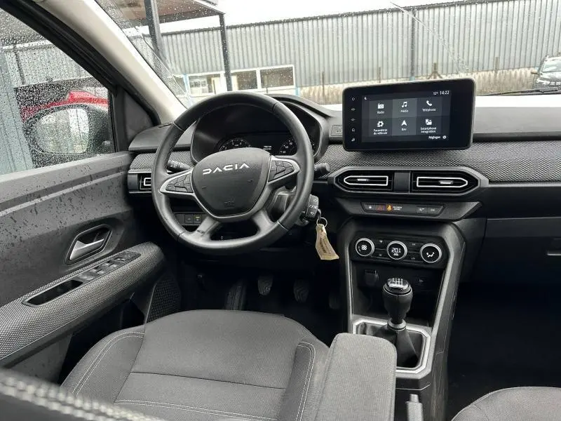 Vue intérieure avant du Dacia Jogger 2025, tableau de bord avec écran tactile et volant multifonction, finition noire.