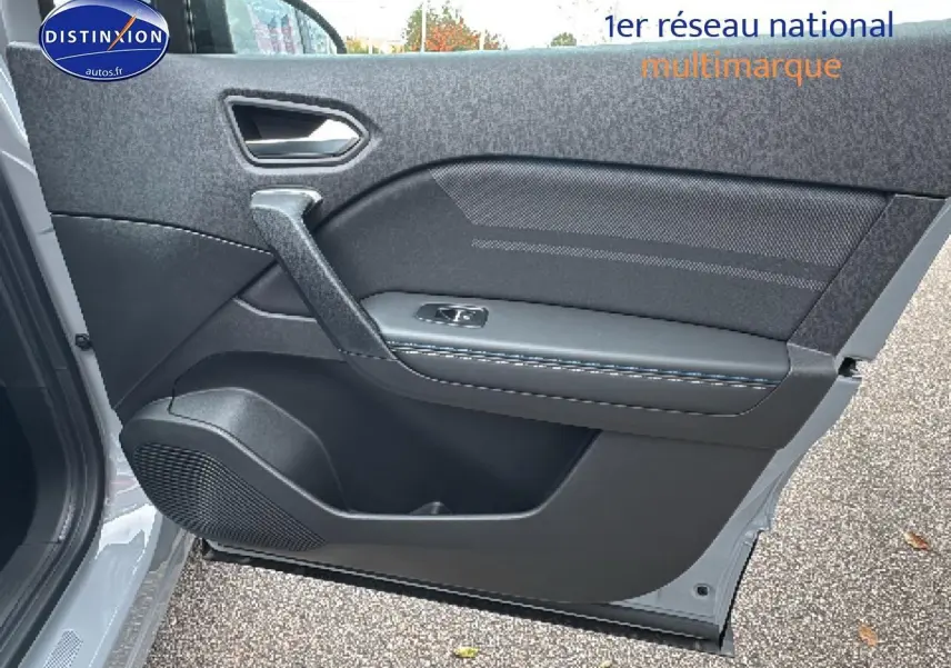 Vue intérieure de la porte avant gauche du Renault Captur gris rafale avec haut-parleur et poignée intégrée.