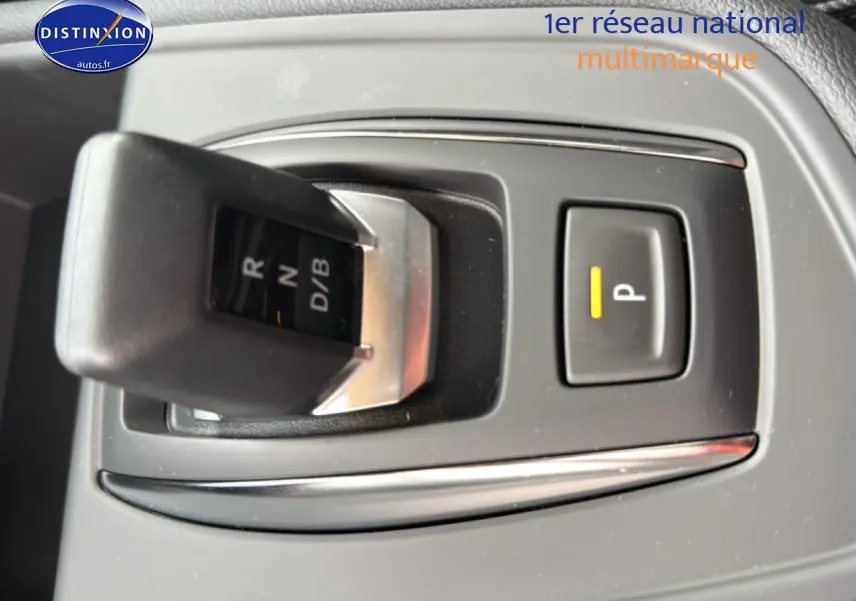 Le levier de boîte automatique et bouton de parking du Renault Captur 1.8 e-tech gris, vue rapprochée intérieure.