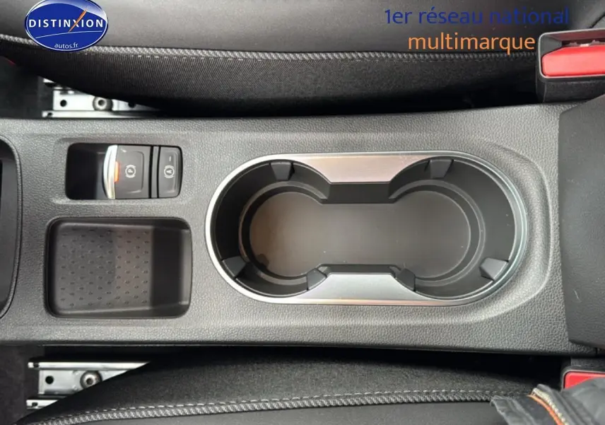 Vue plongeante sur la console centrale grise du Renault Captur 2025 avec porte-gobelets et frein à main électrique.