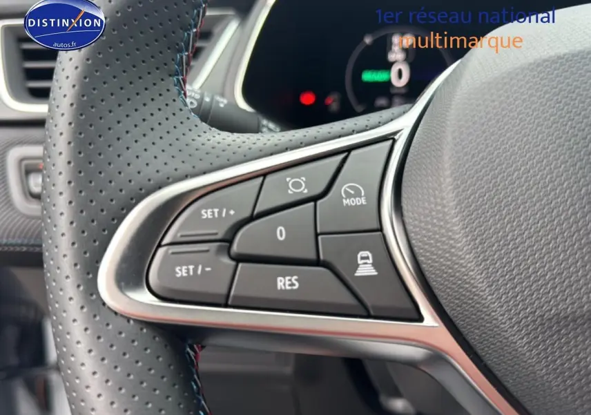 Gros plan sur les commandes multifonctions gauche du volant cuir perforé du Renault Captur gris rafale 2025 esprit alpine.