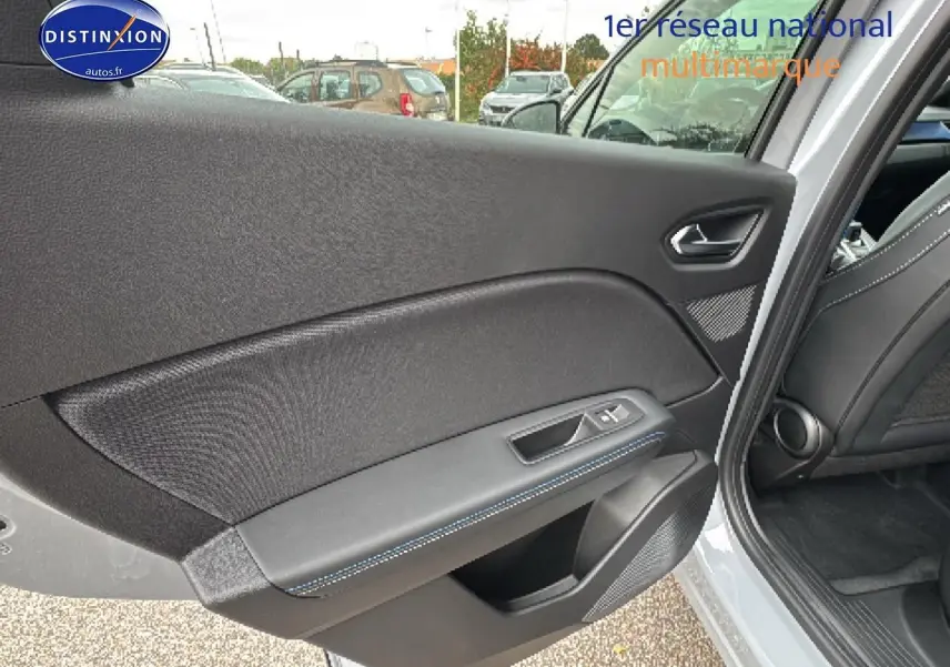 Vue intérieure de la porte arrière gauche du Renault Captur gris rafale, avec surpiqûres bleues et haut-parleur intégré.