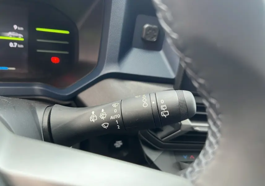Gros plan sur la commande d’essuie-glace côté gauche du tableau de bord du Dacia Duster noir nacré 2026.
