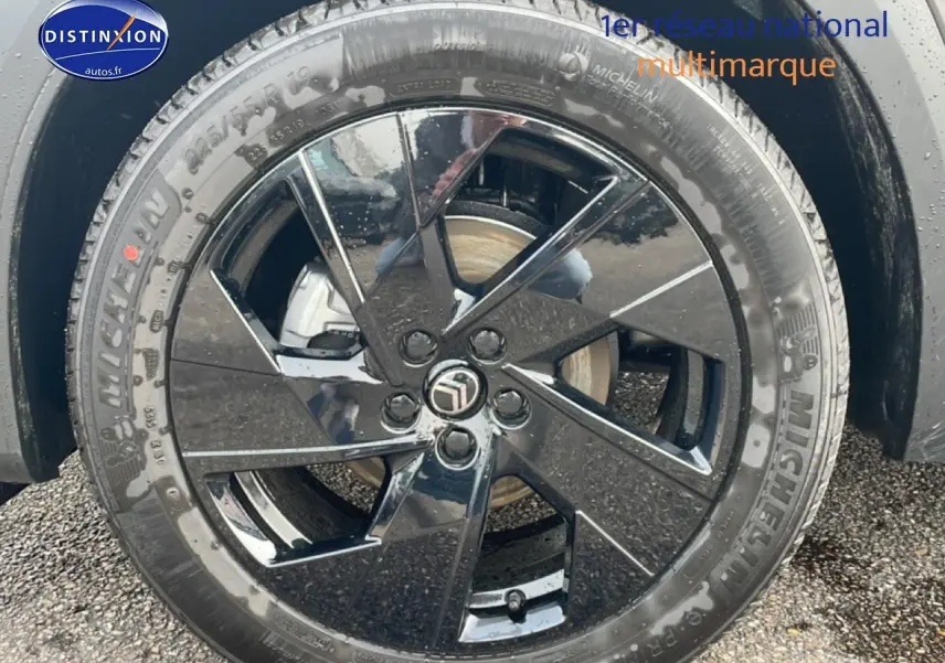 Gros plan sur la jante noire brillante 19 pouces Michelin du Citroën C5 Aircross gris, roue avant droite visible.