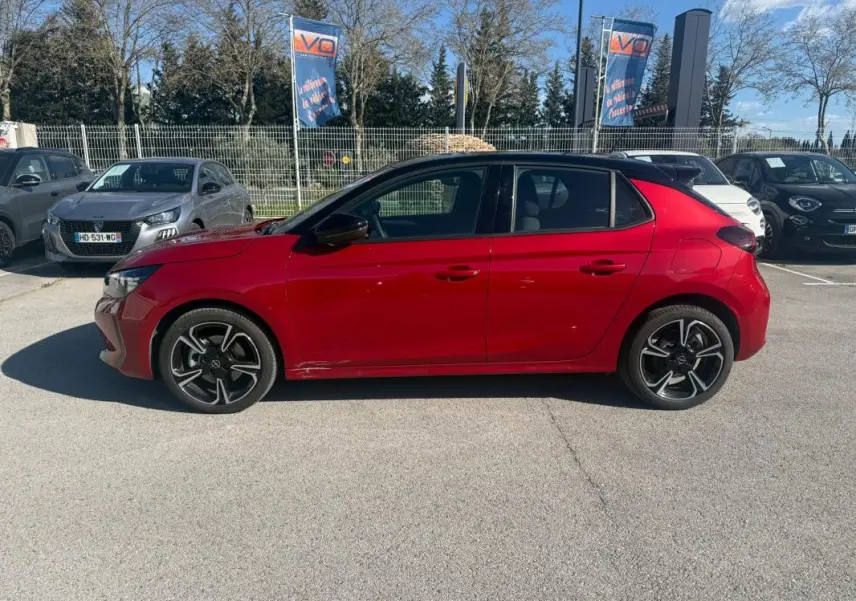 Opel Corsa 2025 rouge vue de profil côté gauche, avec jantes alliage noires et toit noir contrasté.