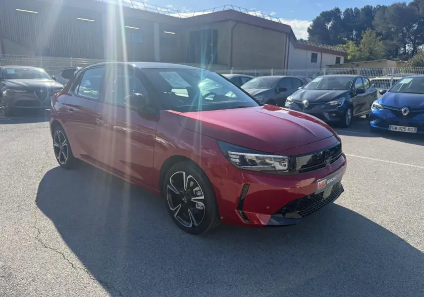 Opel Corsa 2025 rouge vue 3/4 avant droit, avec jantes noires et détails noirs sur la calandre et pare-chocs.