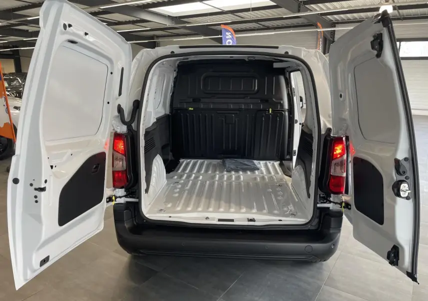 Vue arrière du Peugeot Partner blanc 2026 avec portes battantes ouvertes et compartiment de chargement vide.