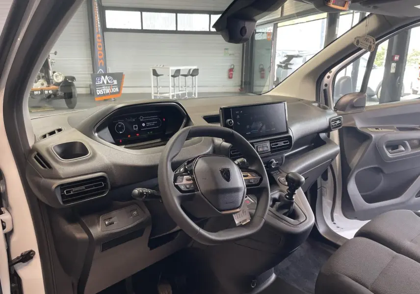 Vue intérieure côté conducteur du Peugeot Partner blanc 2026, tableau de bord moderne avec écran tactile et volant multifonctions.
