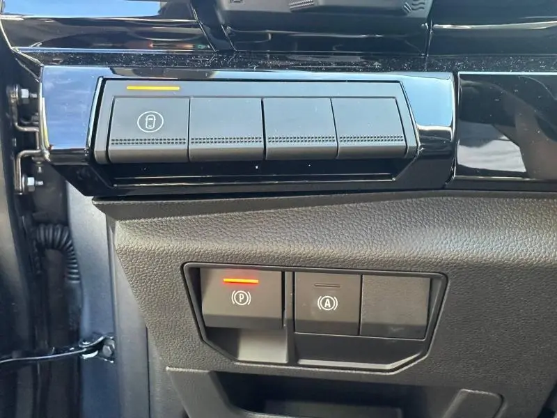Gros plan sur les boutons de commande noirs du tableau de bord côté gauche du Renault Austral gris Schiste avec toit noir.
