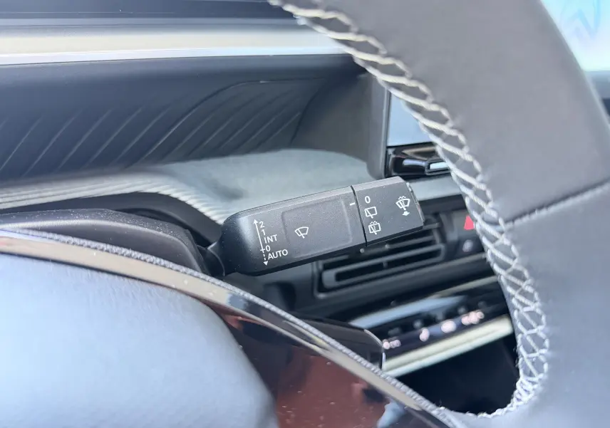 Gros plan sur la manette de commande des essuie-glaces côté gauche du volant de la Citroën E-C3 113 MAX gris Mercury.