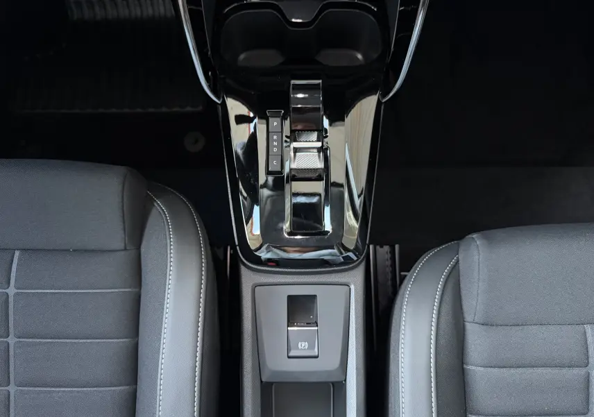 Vue plongeante sur la console centrale brillante et la sellerie tissu noir de la Citroën E-C3 113 MAX gris Mercury.