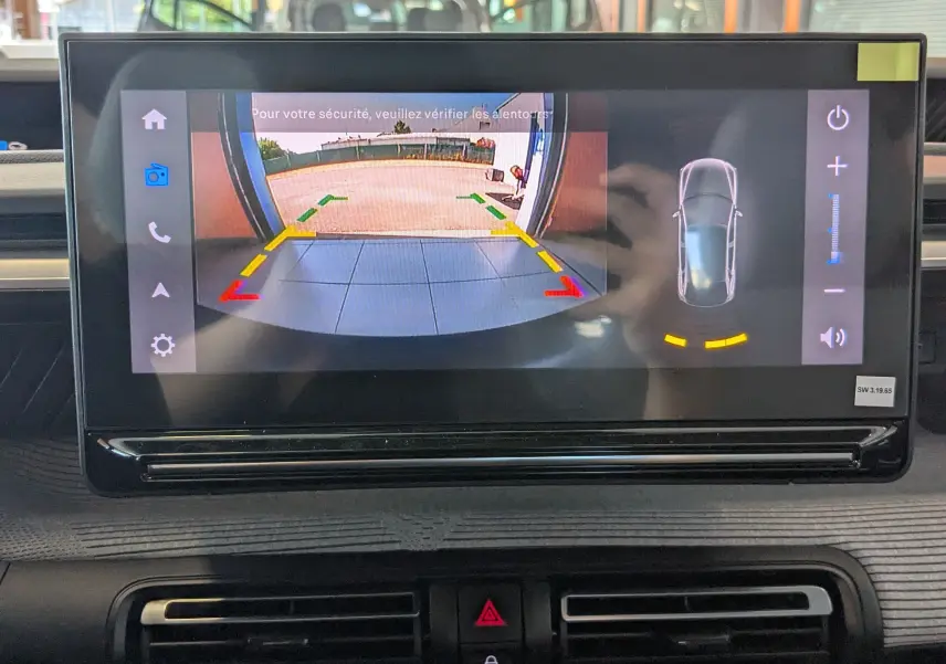 Écran intérieur de la Citroën E-C3 113 MAX montrant la caméra de recul avec guidage de trajectoire et vue 360° du véhicule.